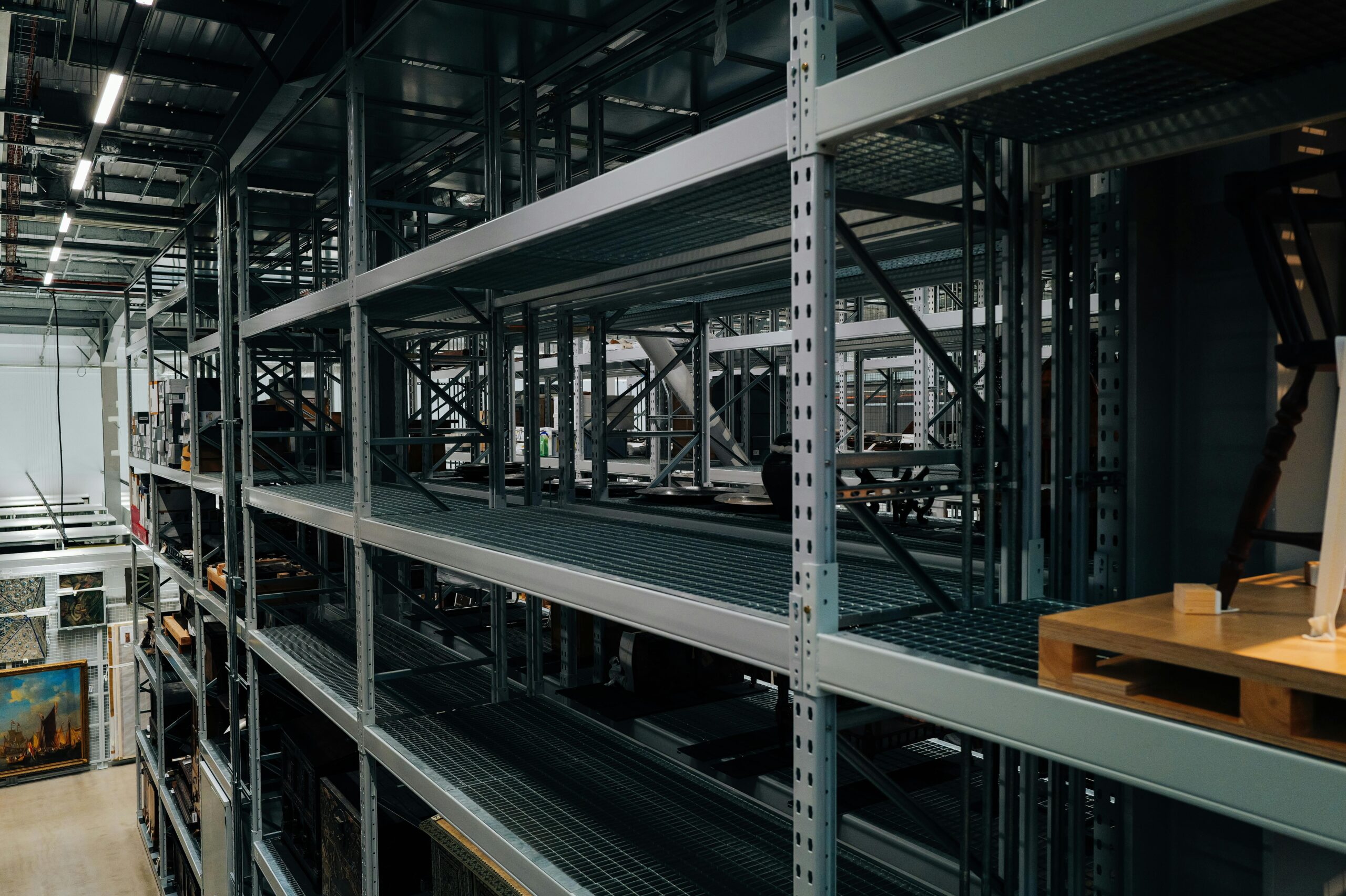 Empty metal storage racks in a spacious industrial warehouse setting.